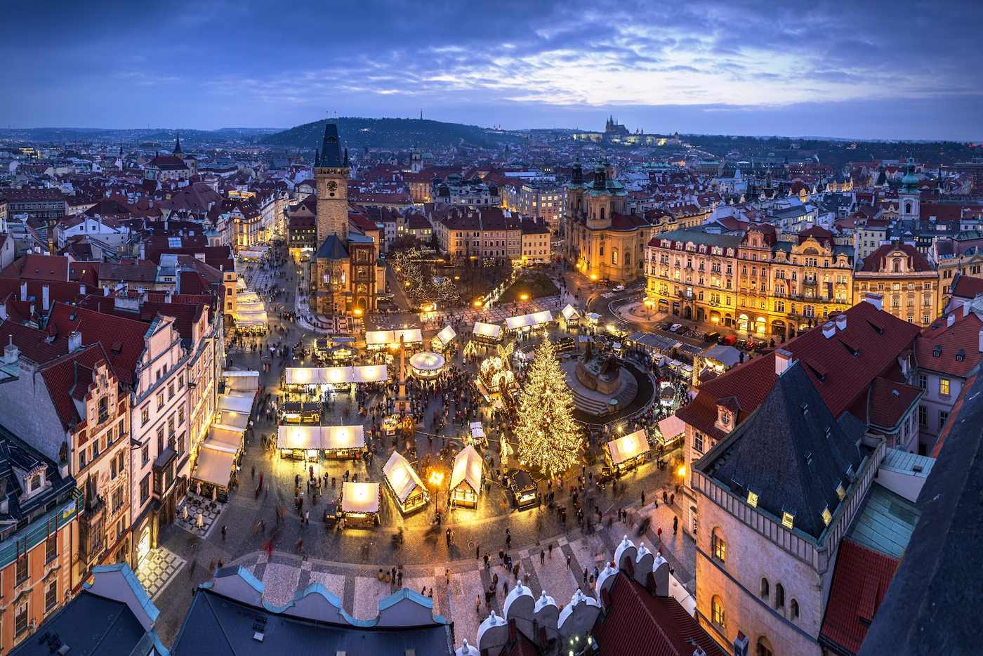 Wide evening view over the roofs of the Old Town towards the Christmas market on Old Town Square.