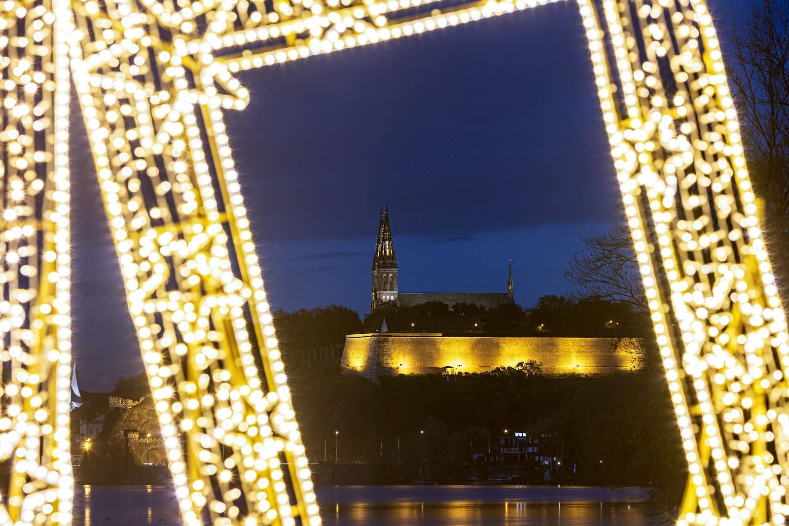View through a light star at the illuminated Vyšehrad above the river at night
