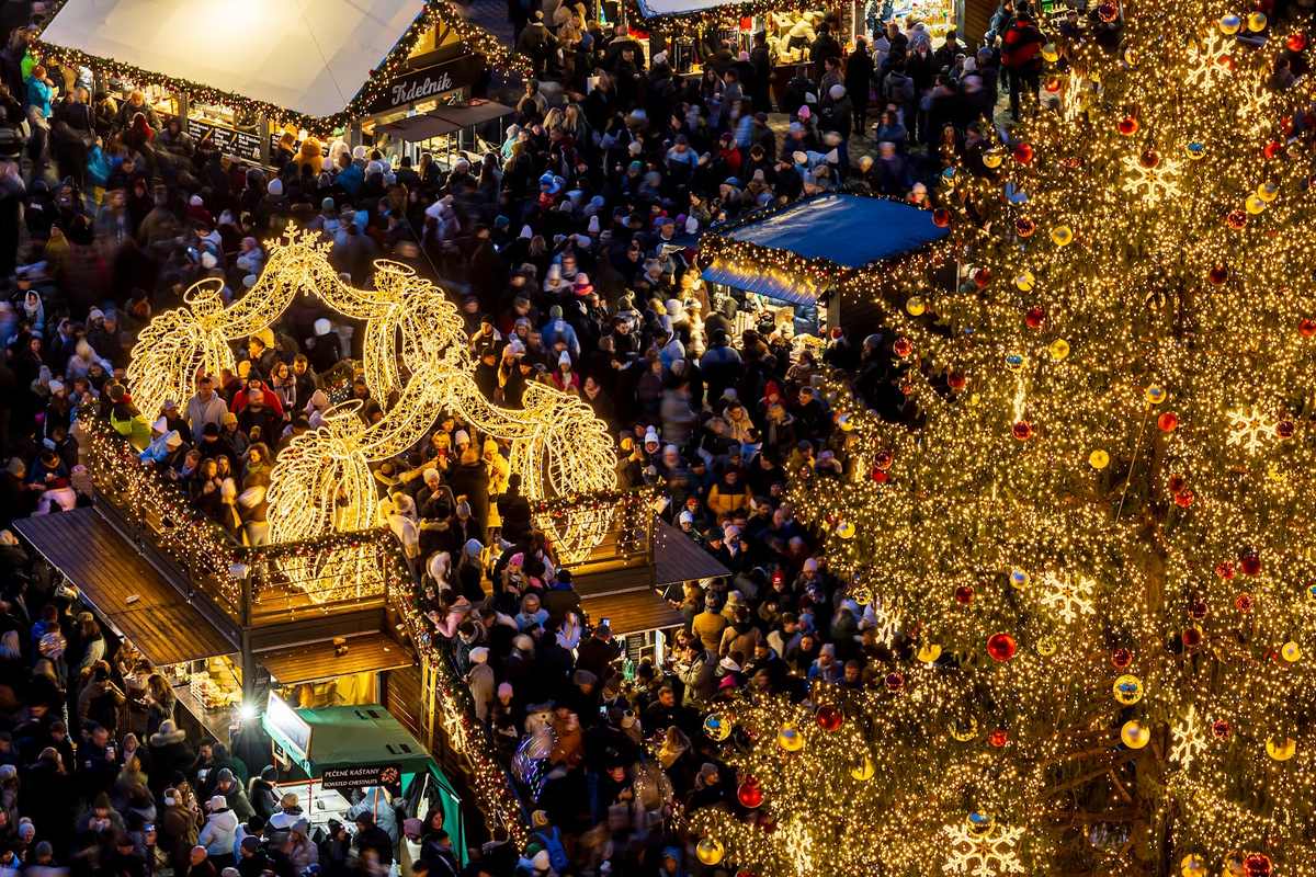 The Christmas tree and lit arches above the market on Old Town Square, seen from above.